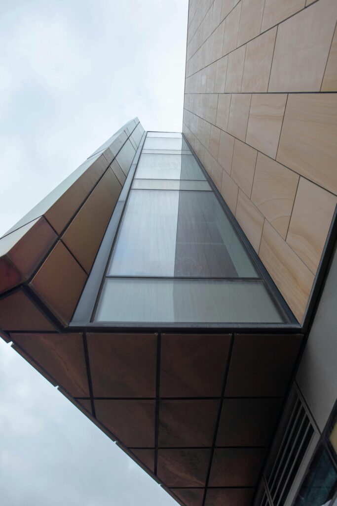 pexels-photo-19783674-19783674 A striking view of contemporary architecture capturing geometric shapes and glass facade from below.